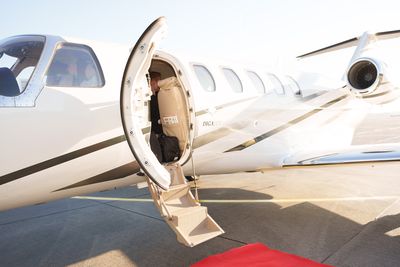 Private jet shoot set organised by Marsha Bagmeijer, open jet door with boarding stairs and red carpet
